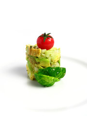 Guacamole tower with cherry tomato on white background