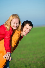 Obraz premium Young love couple smiling under blue sky