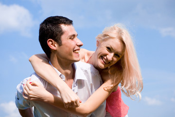 Young love Couple smiling under blue sky