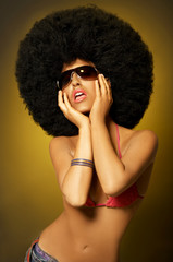 Beautiful woman with huge afro haircut on yellow