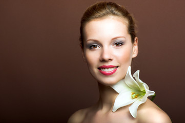 Beauty portrait of a young woman with a lily flower
