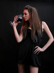 Beautiful young woman with a glass of red wine.