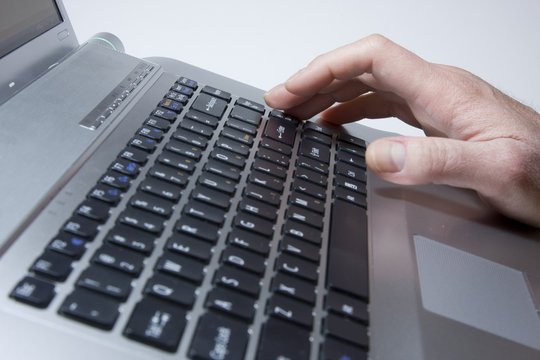 Notebook close-up photo, male hands typing on a laptop
