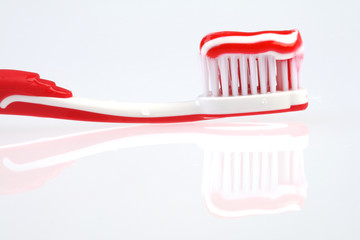 Red toothbrush with striped toothpaste