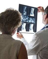 Doctor and Patient Reviewing Scans of Patient's Back - 13581445