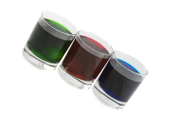 Three glasses with multi-coloured cocktails isolated over white