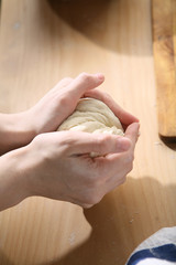 Woman hands kneading dough on the table
