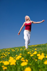 young woman in red outfit having fun on meadow