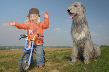 Kind am Laufrad mit großem Beschützer