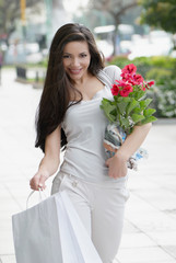 The beautiful young girl with a shopping Bag and flower