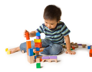 Naklejka premium Cute preschool boy playing with wooden blocks.