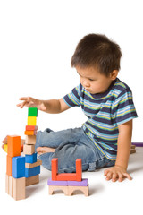 Cute preschool boy playing with wooden blocks