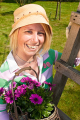 Woman with marguerits in a garden pottery