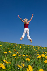 young woman in red outfit having fun on meadow