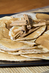 Pancakes with cinnamon sticks on a plate