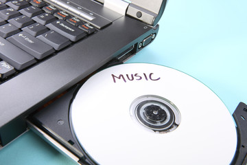 Closeup image of a laptop and a CD / DVD disc