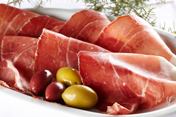 Sliced prosciutto with olive fruit