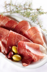 Sliced prosciutto with olive fruit
