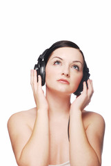 Beautiful brunette woman wearing headphones looking up