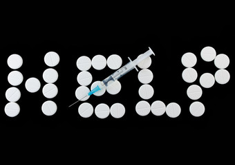 Word -HEPL with syringe on white pills.