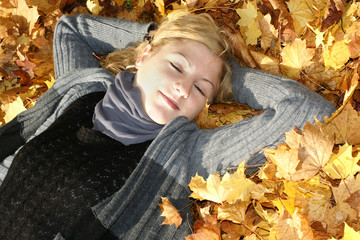 Beautiful young blonde dreaming in leaves