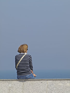 Mujer fumando frente al mar