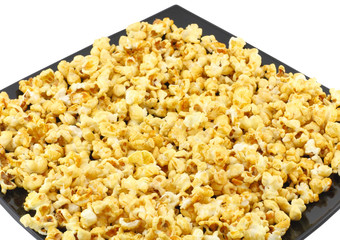 Fragment of plate with fresh caramel popcorn. Isolated