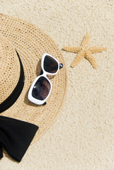 Fototapeta na wymiar Słomkowy kapelusz, okulary i rozgwiazda na plaży