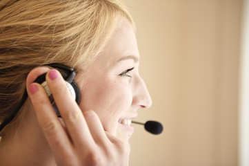 lächelnde frau telefoniert mit headset in büro