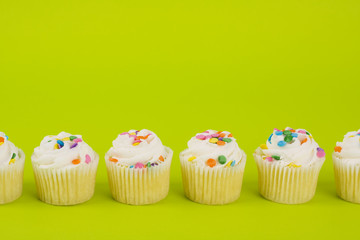 Delicious cupcakes on lime green background