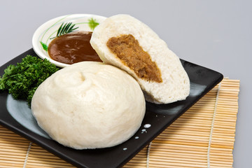 Meat-stuffed steamed bun with hoisin sauce
