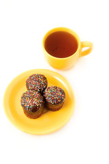 chocolate cake on the yellow plate and cup of tea