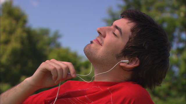 junger mann h&ouml;rt musik mit mp3-player