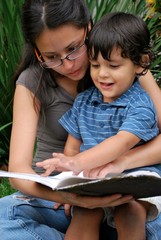 Young Hispanic mother reads to her son