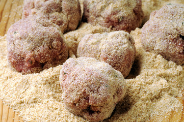 Beef meatballs being prepared on wooden chopping board