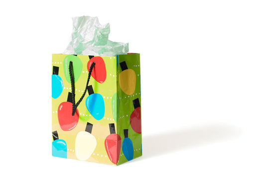 A Festive Gift Bag With Tissue Paper Coming Out.