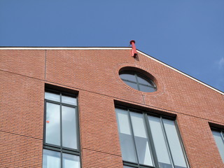 Immeuble en brique rouge, ciel bleu.
