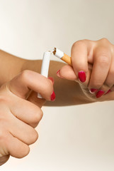 hands of a woman breaking a cigarette