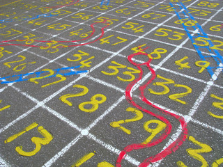 Snakes and ladders numbers game on a children's playground.