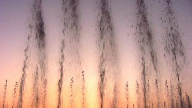 fountain water stream on sky sunset. loop