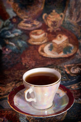 Cup of tea of the Japanese service against a gobelin with the we