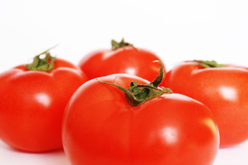 Four red tomatoes isolated. White background