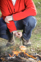 Man grilling sausage on skewer outdoors