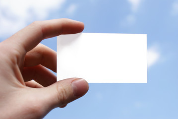 Hand holding up blank businesscard on blue sky