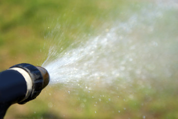 Splash of water in garden on green grass