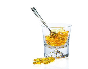 Omega-3 vitamins in glass  and teaspoon