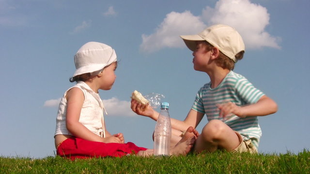 children with food on meadow