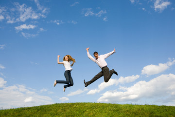 Happy smiling couple  jumping in blue sky