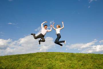 Happy smiling couple  jumping in blue sky