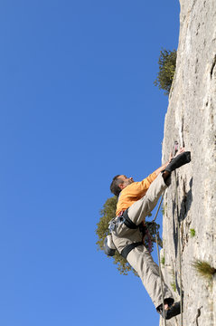 un jeune grimpeur sur une paroie rocheuse, dans le Roussillon.